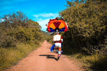 Man wearing Aztec headdress standing outdoor