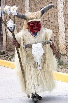 Man wearing devil's mask wearing light outfit