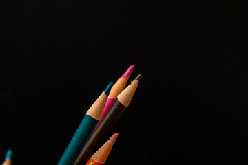 Multi colored coloring pencils on  dark background
