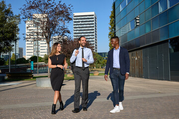 three business people walking down the street and laughing after workday