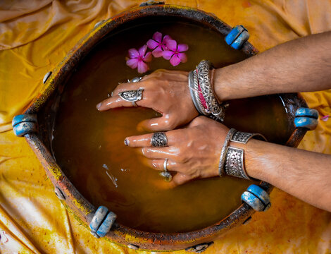 Person in silver bracelet holding brown round container