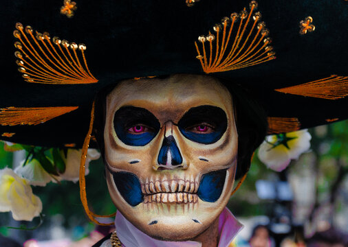 Portrait Of Man With Sugar Skull Face Paint And Sombrero Hat