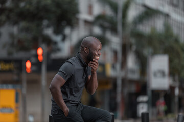 Side view of man in gray polo shirt and gray pants sitting on chair outdoor