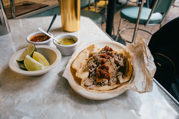 Arabic tacos served on a restaurant table with hot sauces