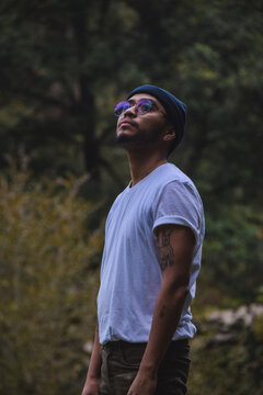 Tattooed man with sunglasses and knit cap standing outdoor