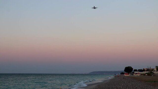 Airplane at most beautiful colorful sunset Ialysos Beach Rhodes Greece.