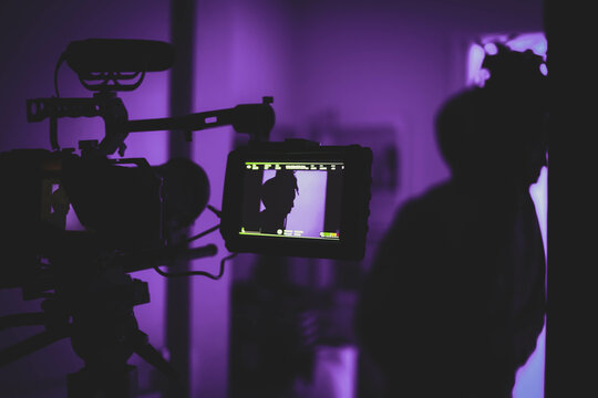 Video camera recording in purple lit room
