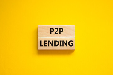 P2P peer to peer lending symbol. Concept words P2P lending on wooden blocks on a beautiful yellow background. Business and P2P peer to peer lending concept. Copy space.