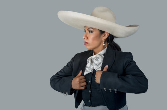 Woman in dark charro suit and sombrero hat