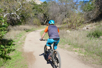 Fototapeta premium man on a mountain bike heading up a dirt trail