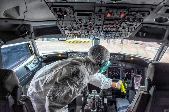 Worker in PPE disinfecting airplane control room at Soekarno-Hatta Airport