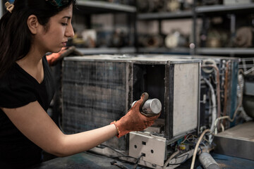 Young woman installing an electrical part into a machine