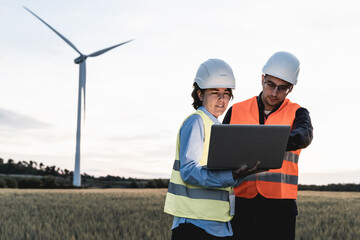 Renewable clean energy - Engineer people working with digital tablet at wind farm - Soft focus on woman face