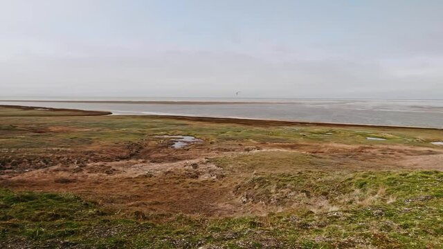 Panoramic view of landswell of Yamal peninsula and Kara sea. Flock of geese flying in the sky over water.