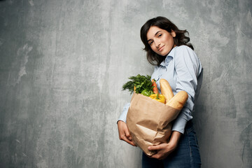 woman with a package of groceries vegetables healthy food studio supermarket