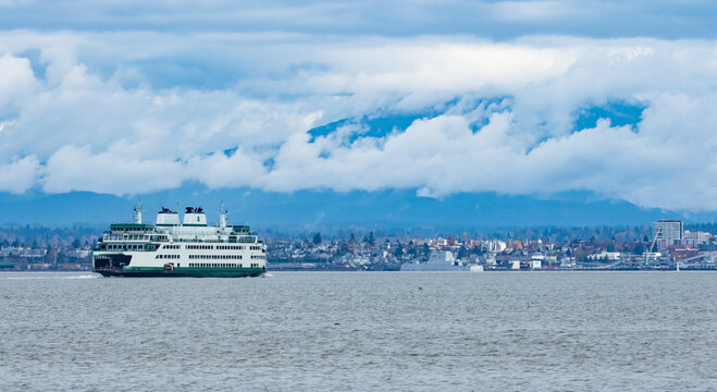 Washington State Ferry Travels Towards Mukilteo On a Cloudy Day With Everett Washington in Background