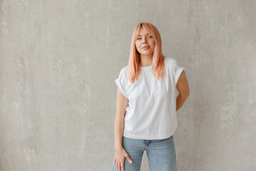 Young girl wearing blank white t-shirt. Concrete wall background