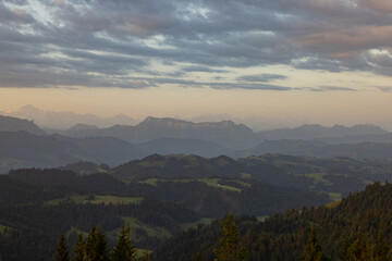 Amazing sunset at a wonderful landscape in Switzerland on a hill called Napf. Wonderful morning view with the alps in the horizon.