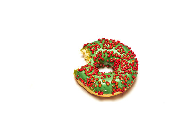 Green round bitten donut isolated on white background. Christmas colors