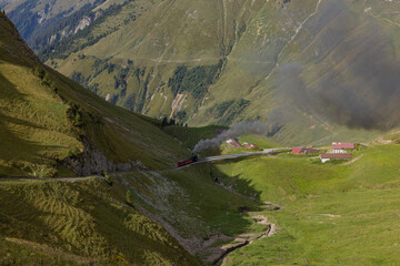 Amazing hiking day in the alps of Switzerland. A beautiful locomotive drives on to a mountain and a...