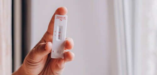 woman holding Rapid Antigen Test kit with Positive result during swab COVID-19 testing. Coronavirus...