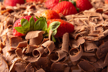 Chocolate cake, details of a beautiful chocolate cake with strawberries, abstract background, selective focus.