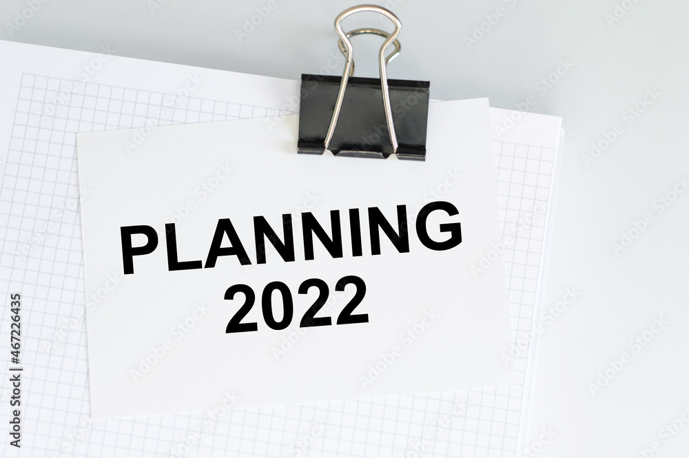 Aufkleber planning 2022 text on the paper with a clip on a notepad on the table. business concept
