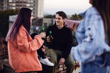 A teenagers hanging on rooftop and drinking beer.