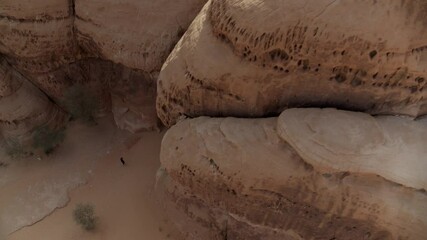 Aerial: Tourists Exploring Mada�In Salih During Vacation, Drone Flying Over Rock Formation - AlUla, Saudi Arabia