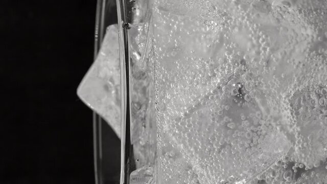 Pour lemon soda water into a glass, splash water, in it there is a cube of ice. many bubbles , Soft drinks are unhealthy because they have a lot of sugar.
