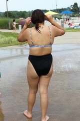 Backside of young woman in bikini at poolside
