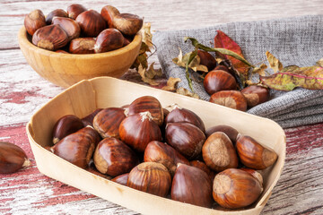 A pile of chestnuts filling a small wooden bowl ready to peel and eat