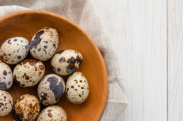Fototapeta premium quail eggs in wooden plate over dark old wooden background