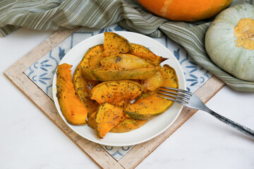 Plate of baked pumpkin with provencal herbs and walnuts. Vegetarian autumn Thanksgiving food.