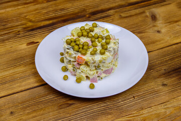 Traditional Russian festive salad Olivier on wooden table