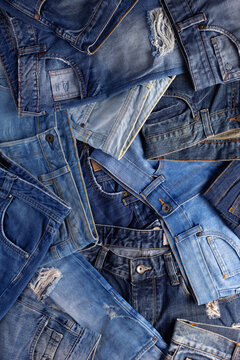 Stack of blue jeans denim. Jeans heap with wooden background texture