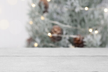 Christmas tree background for digital product mockups. Indoor styled scene with an empty, grey, wooden table.