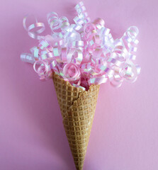 Close-up on ice cream cone with conffetti on the pink background