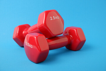 Dumbbells in a plastic sheath on a blue background. Sports inventory. Training workout equipment. Sport and exercises.