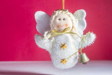 christmas ornament, concept with little angel, white and red background, copy space and selective focus.