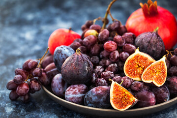 Fresh autumn fruits -  figs, plums, grapes and pomegranate