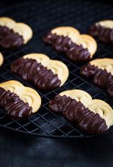 Homemade chocolate dipped shortbread cookies on dark background