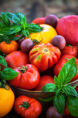 Fresh ripe red and yellow tomatoes on rustic background