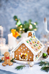 Homemade Christmas gingerbread house with holiday   decorations, candles and lanterns on  background