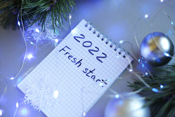 new year notepad with plans, light bulbs, garlands, balls