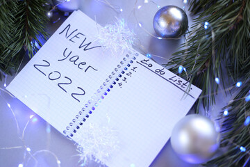 new year notepad with plans, light bulbs, garlands, balls