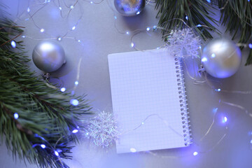 new year notepad with plans, light bulbs, garlands, balls