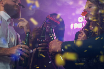 Happy group of friends dancing on a party in a club