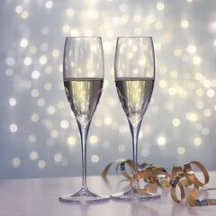 Two glasses of champagne against blurred lights