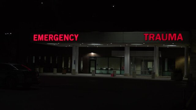 Good night establishing shot of a generic modern hospital with emergency room and trauma center.
